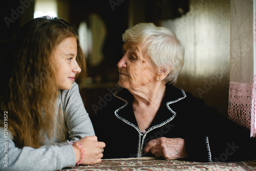 Obraz na płótnie A teenage girl and her grandmother (or great-grandmother) spending time together. w salonie