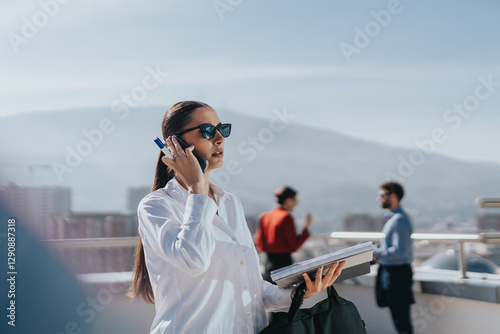 Tableau sur toile A confident businesswoman in sunglasses stands on a high tower balcony, talking on her phone, exuding professionalism