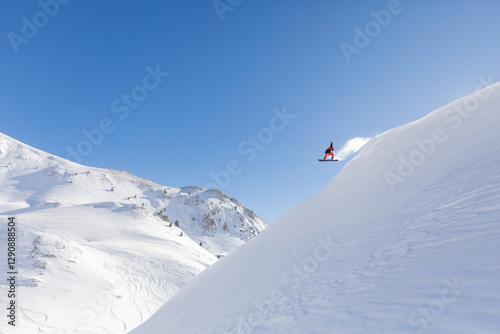 Snowboarder Performing Jump on Snowy Mountain Slope photo