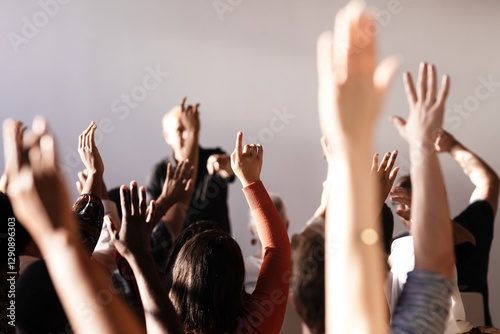 Konstfotografi A diverse group of people raising hands in a classroom or seminar setting, focusing on participation and engagement