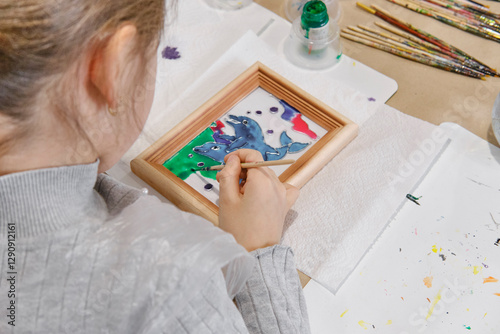 Fototapeta Naklejka Na Ścianę i Meble -  Childs hands coloring in stained glass painting technique picture