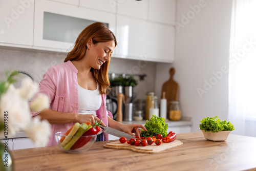 Obraz na plátne Beautiful young woman stand at modern kitchen chop vegetables prepare fresh vege