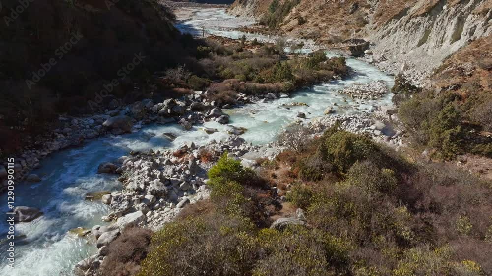 Aerial view capturing Dudh Koshi River winding through rugged Himalayan terrain, revealing untouched wilderness surrounding Ama Dablam rocky valley Aerial view capturing Dudh Koshi River winding through rugged Himalayan terrain, revealing untouched wilderness surrounding Ama Dablam rocky valley