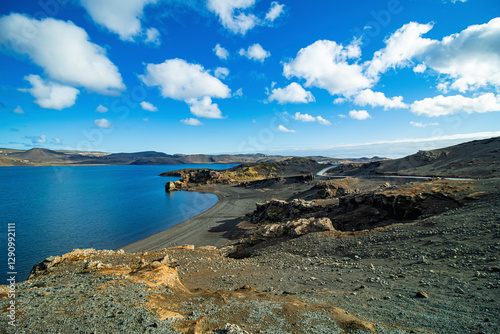 View of serene lake surrounded by rugged mountains and a tranquil sky, Krysuvik, Iceland. photo