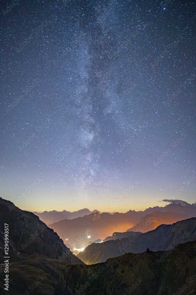 View of the milky way over majestic mountains and a tranquil valley at dusk, Passo Giau, Cortina d'Ampezzo, Italy.