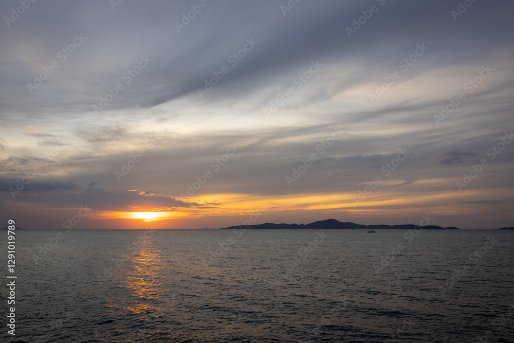Obraz premium A serene seascape with a distant island silhouetted against the twilight sky