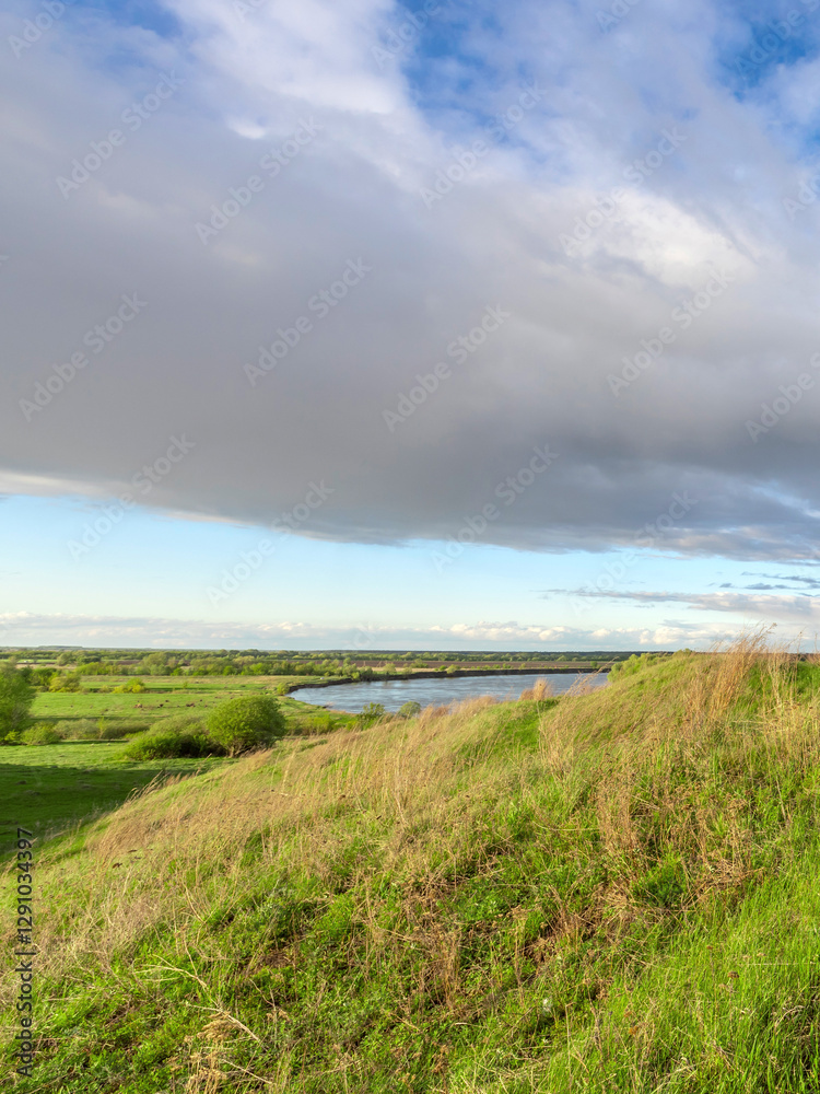 Obraz premium Cloudy sky with a river in the background