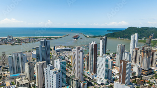 Fototapeta Naklejka Na Ścianę i Meble -  Panoramic photograph of the city of Itajaí and its Itajaí-Açu River flowing into the sea, with a ship maneuvering.