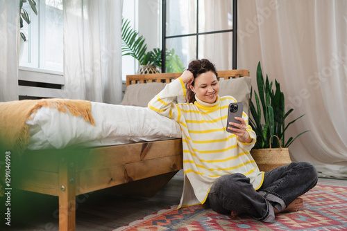 Woman Enjoys Relaxing Digital Moment at Home on Smartphone photo