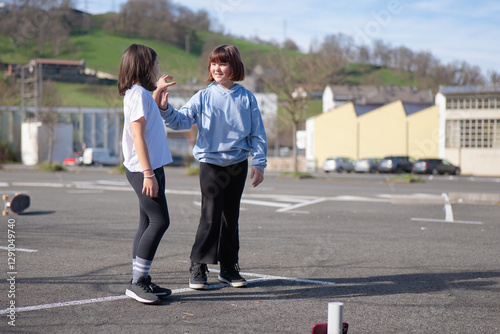 Two friends playing outdoors in a sunny urban parking lot