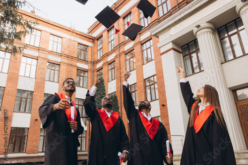 фотографія Joyful Graduates Celebrating In Front of University Building, Tossing Caps In th