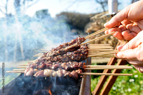 Arrosticini di pecora or sheep skewers is a typical food of Abruzzo in Italy cooked on Furnacella characteristic brazier for their cooking photo