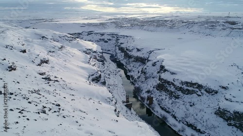 Wallpaper Mural A breathtaking aerial view of a snow-covered deep canyon. The river flowing through the rocky valley showcases the wild and mesmerizing beauty of nature. Winter and canyon landscape. Torontodigital.ca