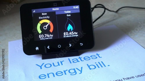 Energy smart meter and consumption account. Electricity and gas meter with the electricity meter needle moving up and down with an account bill.