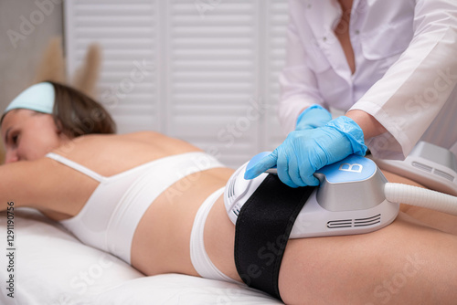professional electrostimulation session, close up view o therapist applying EMS device on woman in modern clinic, muscle toning, body sculpting, fitness industry