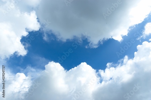 Fototapeta Naklejka Na Ścianę i Meble -  Thick clouds behind the hot sun. Beautiful white clouds in the bright blue sky as a natural concept.