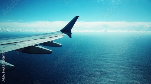 Wallpaper Mural The silhouette of an airplane wing soaring over a deep blue ocean, with the horizon meeting the sky on a clear day during a transatlantic flight. Torontodigital.ca