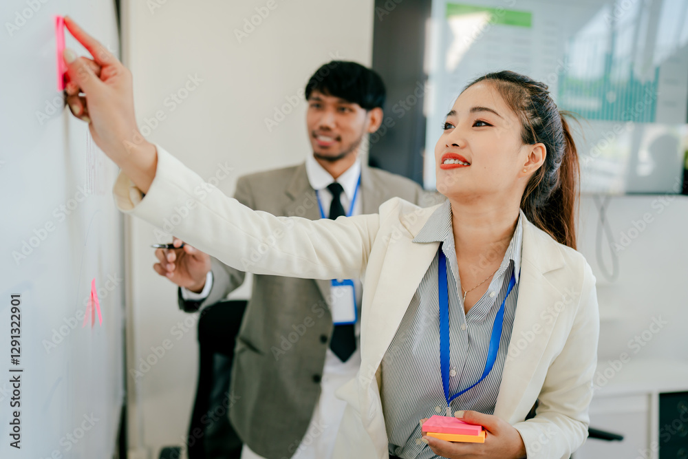 Fototapeta premium Woman and a man are working together on a whiteboard