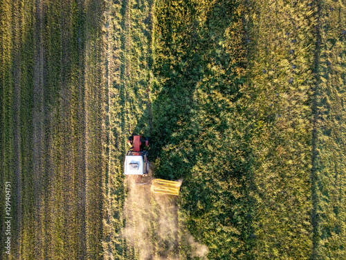 Obraz na płótnie A tractor during summer field work in a field in the Masovian Voivodeship in Poland. w salonie