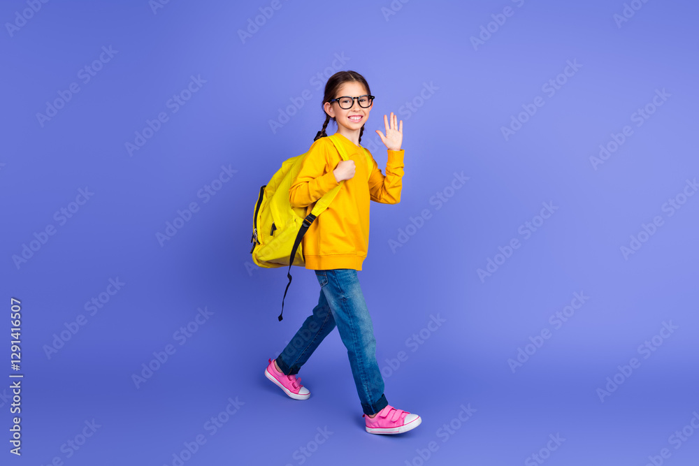 Smiling schoolgirl with a backpack waving hand on purple background wearing casual outfit, showcasing youth and style Smiling schoolgirl with a backpack waving hand on purple background wearing casual outfit, showcasing youth and style