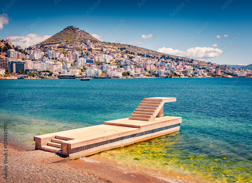 Sunny summer cityscape of Saranda port with empty concrete pier. Warm afternoon landscape of Ioninan sea resort. Picturesque outdoor scene of Albania, Europe. Traveling concept background. Sunny summer cityscape of Saranda port with empty concrete pier. Warm afternoon landscape of Ioninan sea resort. Picturesque outdoor scene of Albania, Europe. Traveling concept background.