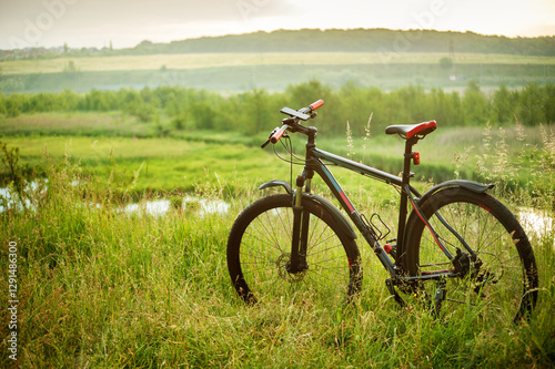 silhouette of a mtb bicycle from hills beautiful views of the floodplains bel...