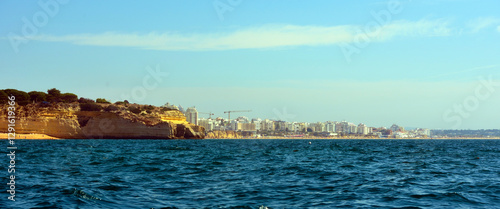 The Algarve rock formation is a unique and amazing natural wonder located in the coastal town of Porches in the background armacao de pera portugal