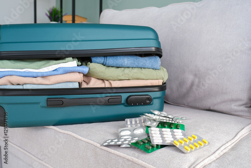 Clothes and pills in a travel bag. Concept of medication required in journey