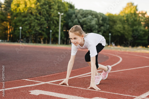 Pre-teen girl ready to race on an athletics track. confidence, empowerment, teamwork, accomplishment, and healthy physical habits
