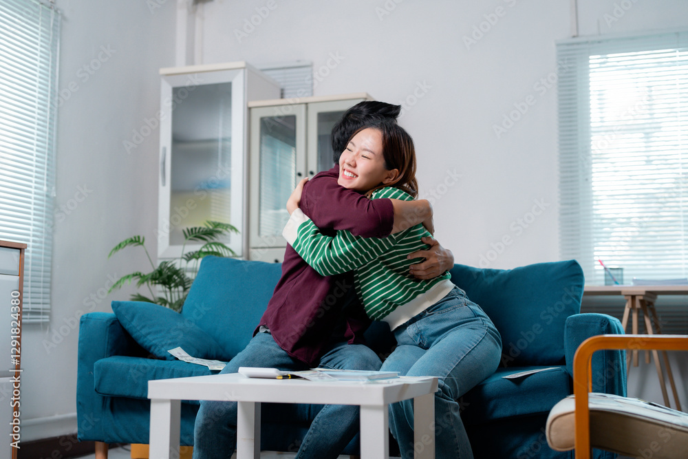 Obraz premium Happy couple hugging on sofa after choosing new house plan