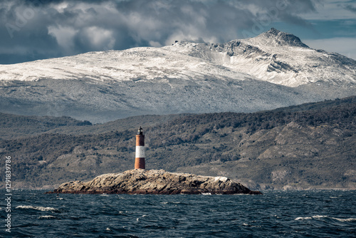 View of dramatic landscape in beagle channel with Les Eclaireurs lighthouse on  the island and snowcapped mountains scenery in background during sunny day. Tierra del Fuego, Ushuaia, Argentina. photo