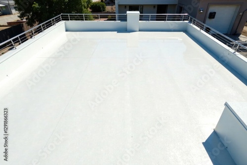 A newly constructed modern flat roof with a white seamless coating and stainless steel railings