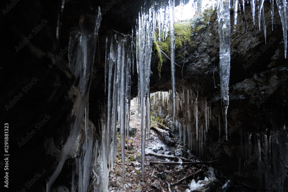 interni di un'antica cavità artificiale scavata nella roccia con formazioni di stalattiti di ghiaccio, in inverno