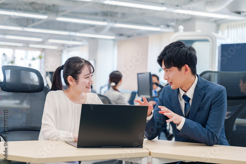 先輩社員から業務を教えてもらう新人の女性 photo