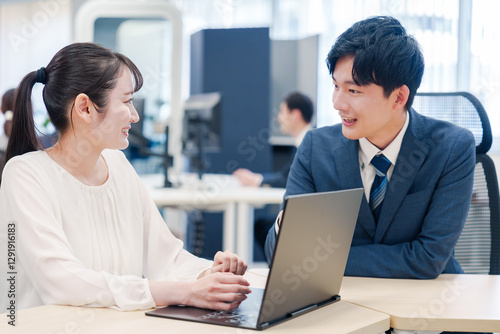 先輩社員から業務を教えてもらう新人の女性 photo