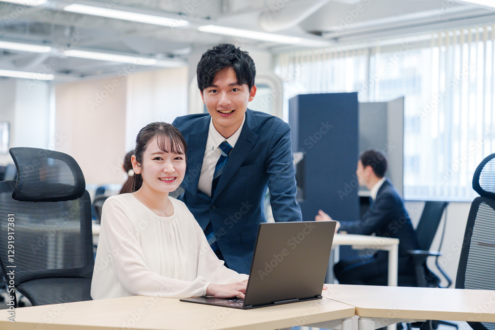 先輩社員から業務を教えてもらう新人の女性 先輩社員から業務を教えてもらう新人の女性