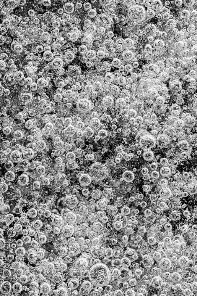 A macro photograph of air bubbles trapped in the ice of a frozen lake. The bubbles vary in size and create a unique, abstract pattern formed by natural processes. A macro photograph of air bubbles trapped in the ice of a frozen lake. The bubbles vary in size and create a unique, abstract pattern formed by natural processes.