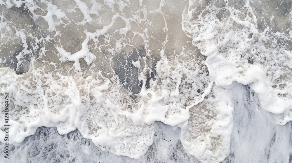 Fototapeta premium Ocean waves crashing onto the shore creating foamy textures