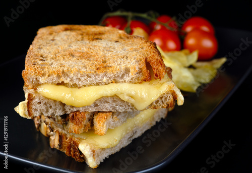 Bild auf Leinwand A sandwich with grilled cheese on the black plate