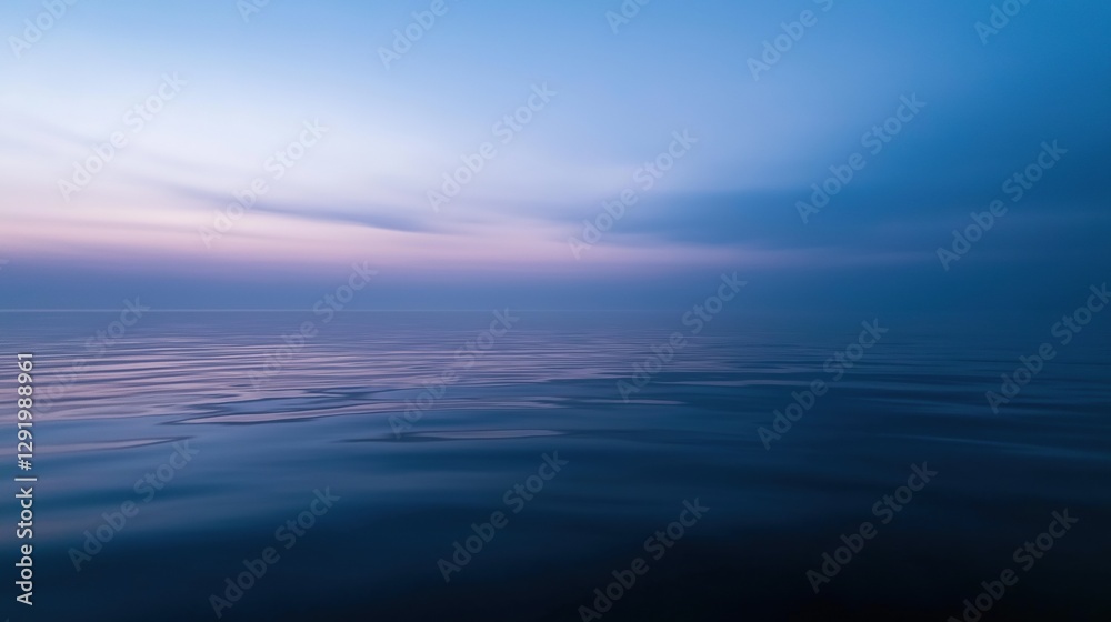 Obraz premium Photograph of a vast body of water. the water is calm and still, reflecting the colors of the sky. the sky is a deep blue with a few wispy clouds scattered across it.
