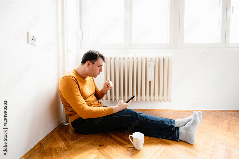Man coughing While Sitting on the Floor Near a Radiator Man coughing While Sitting on the Floor Near a Radiator