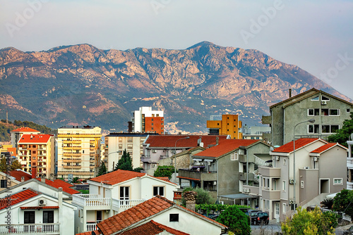 Obraz na płótnie A mountain backdrop overlooking the bustling hillside district of Budva at dusk. w salonie