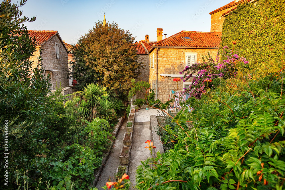 Charming garden pathway in a serene stone village at sunset
