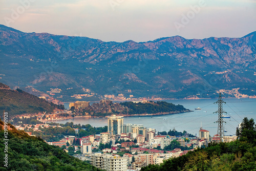 Obraz na płótnie A picturesque view of the coastal town of Budva nestled between mountains at dusk. w salonie