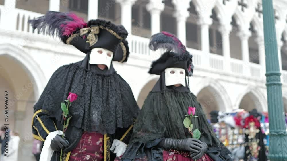 Venice, Italy - People dressed in carnival masks are photographed by tourists in the scenery of the ancient Venetian palaces
