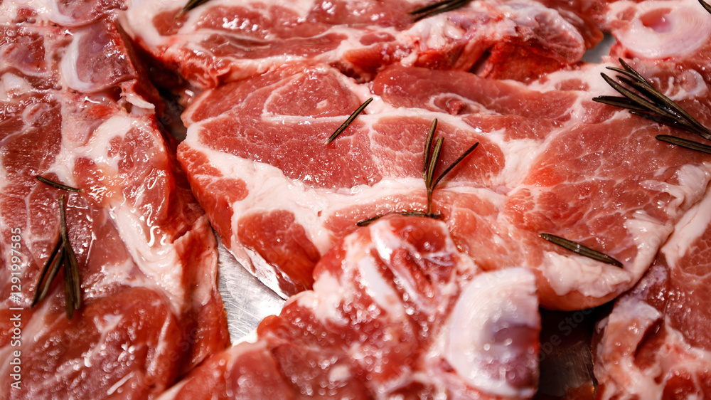Freshly cut pork chops with rosemary on a tray Freshly cut pork chops with rosemary on a tray