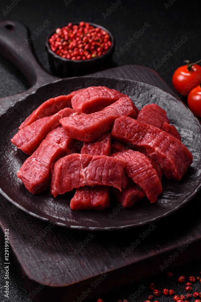 Raw beef tenderloin cut into slices with salt and spices Raw beef tenderloin cut into slices with salt and spices