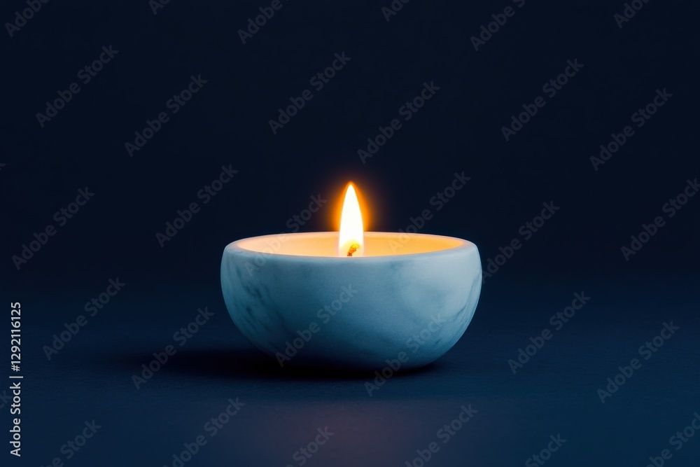 a candle in a small bowl burning on a dark background a candle in a small bowl burning on a dark background