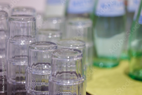 stacks of empty glasses and bottles of water prepared for self-service