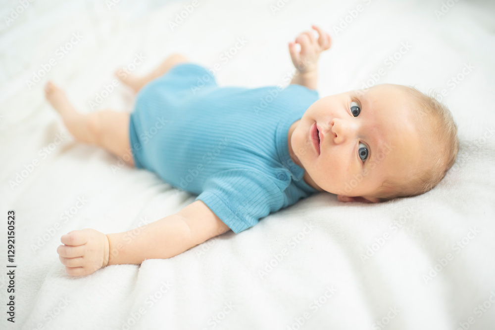 Portrait of baby boy lyingon a white bed. Baby is 2 months old. Happy baby morning. Portrait of baby boy lyingon a white bed. Baby is 2 months old. Happy baby morning.